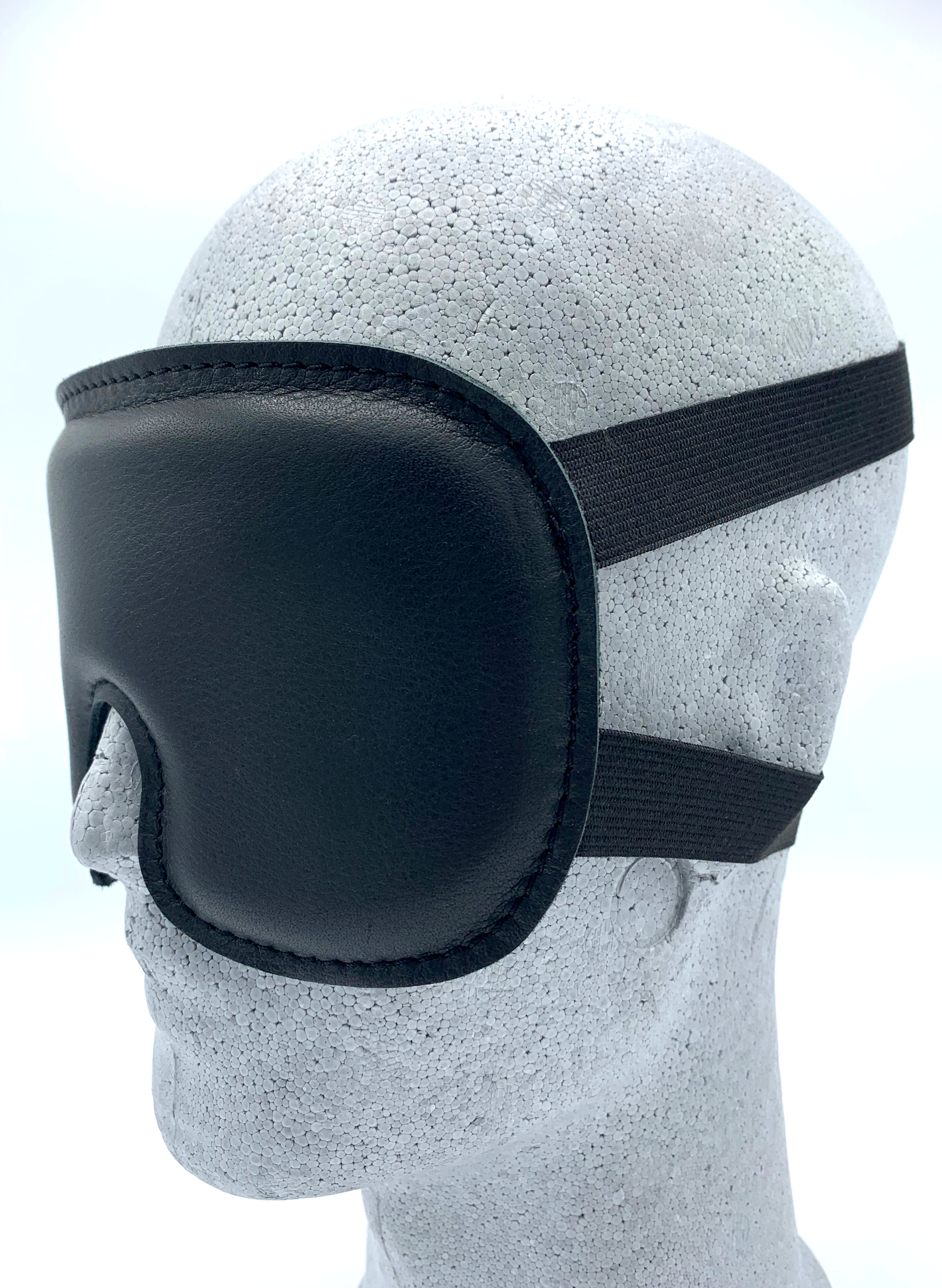 Hochwertige Augenmaske in Schwarz, innen und außen mit Leder bezogen, weich gepolstert und mit flexiblen Elastanbändern für angenehmen Tragekomfort.