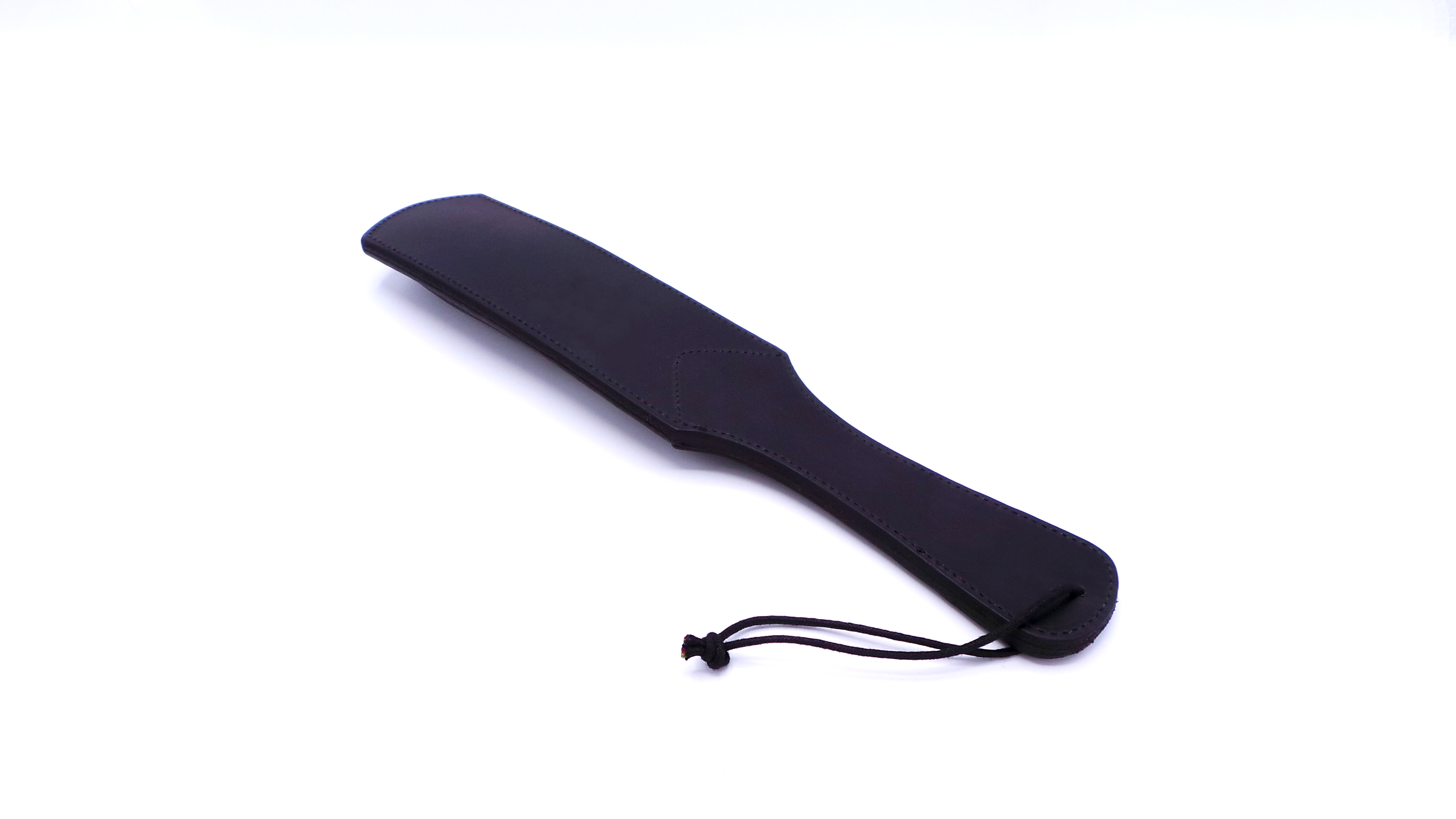 Seitliche Ansicht eines schwarzen BDSM-Paddels aus Rindsleder mit gepolsterter Schlagfläche und stabil vernähtem Griff.