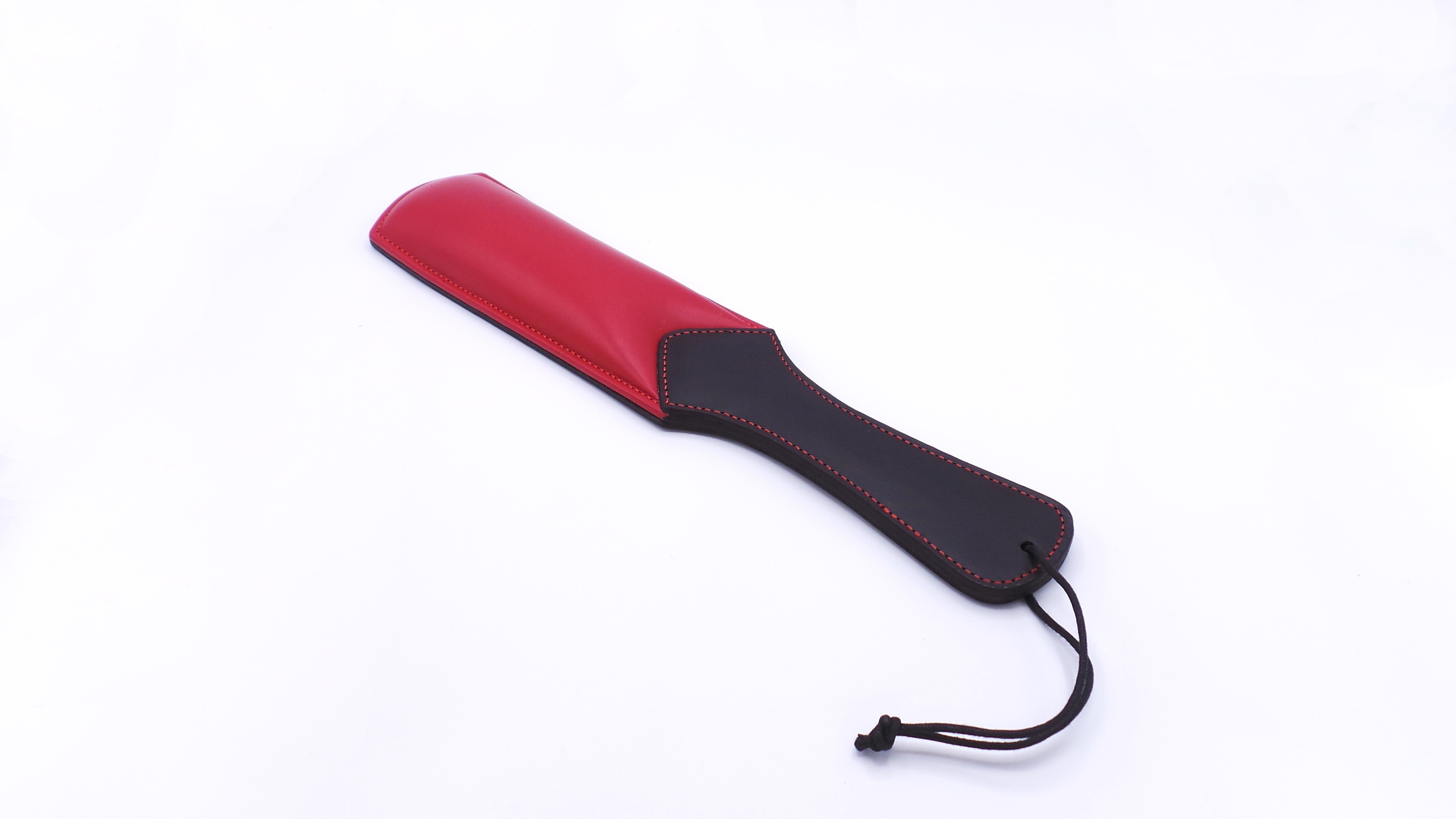 addel aus schwarzem und rotem Rindsleder, ca. 37 cm lang, mit gepolsterter Schlagfläche und Handschlaufe.