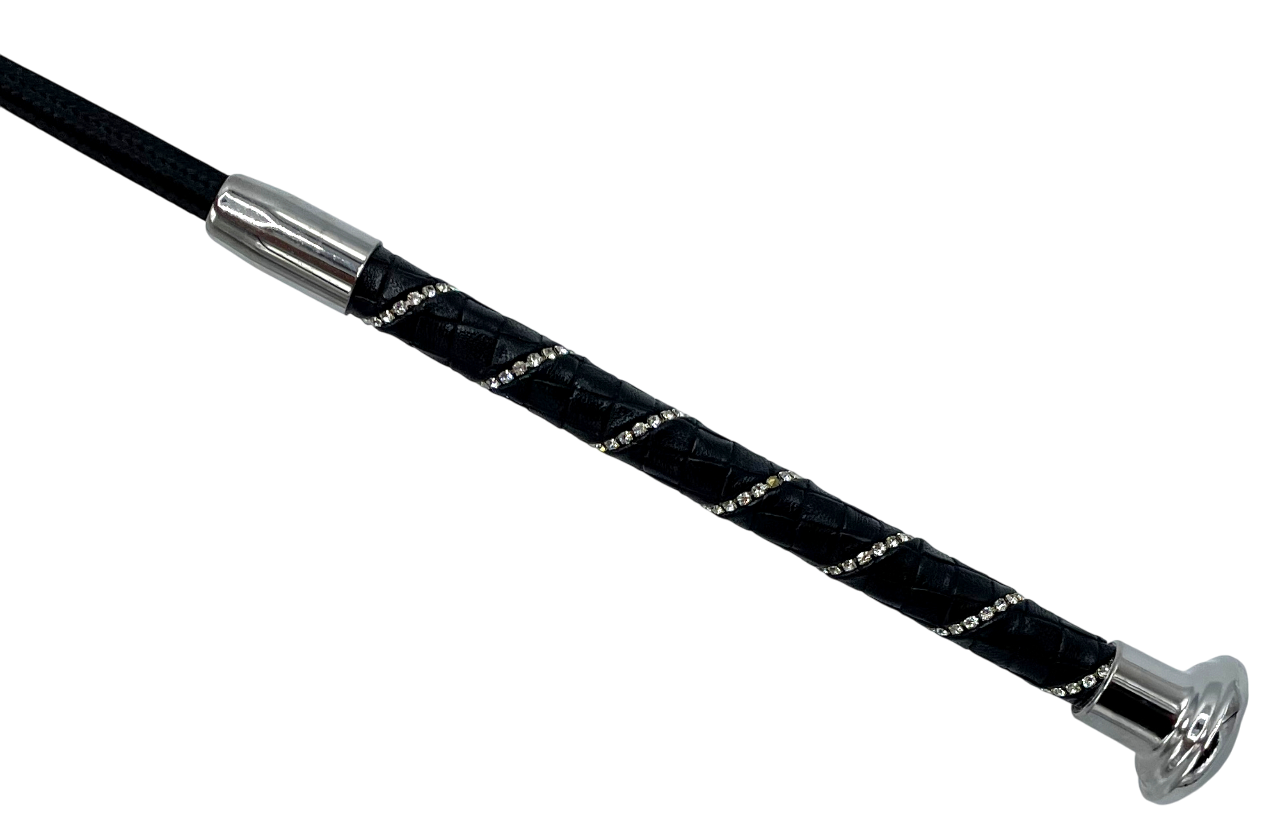 Detailaufnahme des schwarzen Griffs einer Gerte, mit Lederummantelung im Rautenmuster und funkelnden Glitzersteinen, silberne Endkappe.