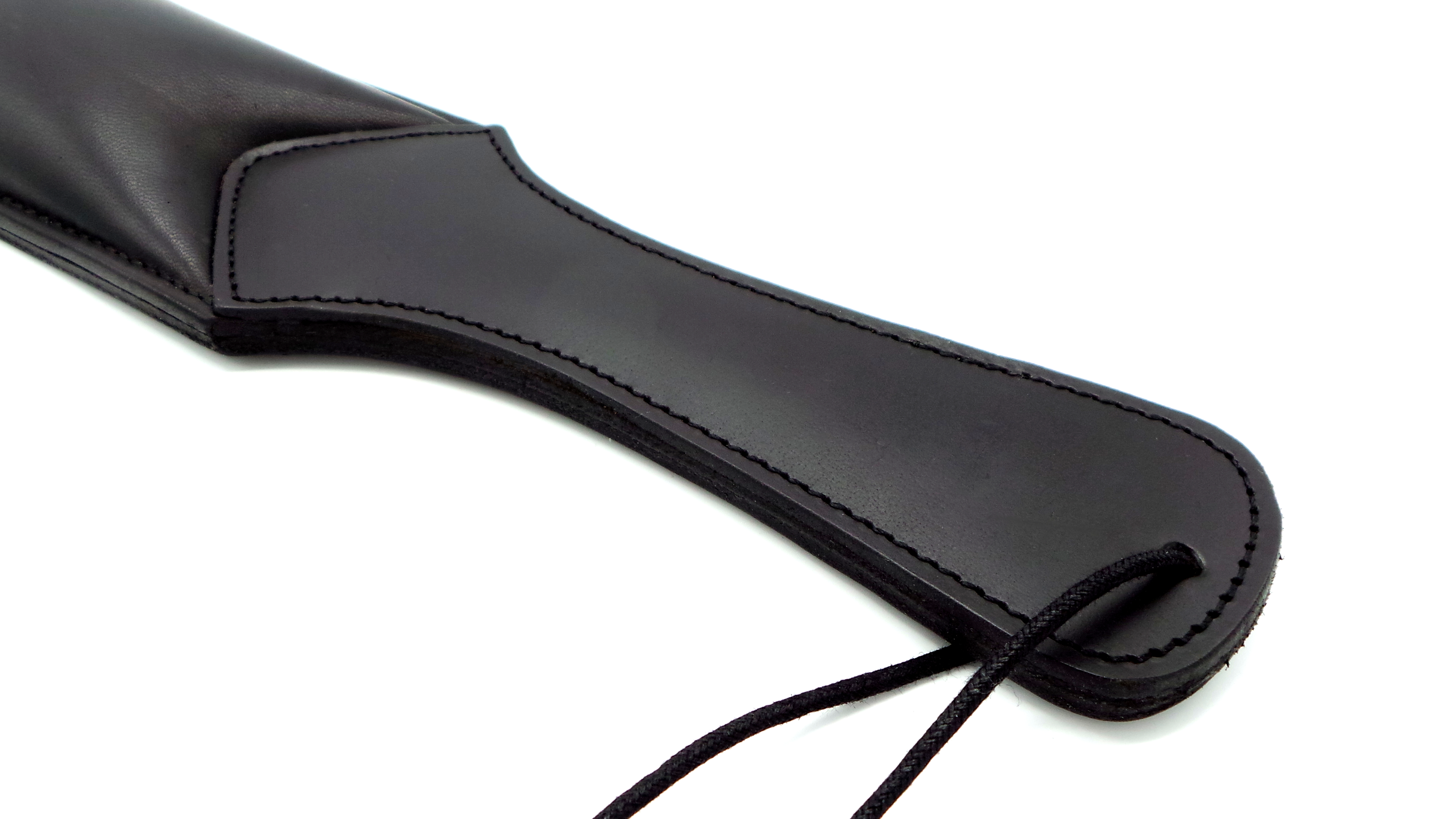 Nahaufnahme des Griffs eines gepolsterten Paddels aus schwarzem Rindsleder, mit feinen Nähten und integrierter Handschlaufe.