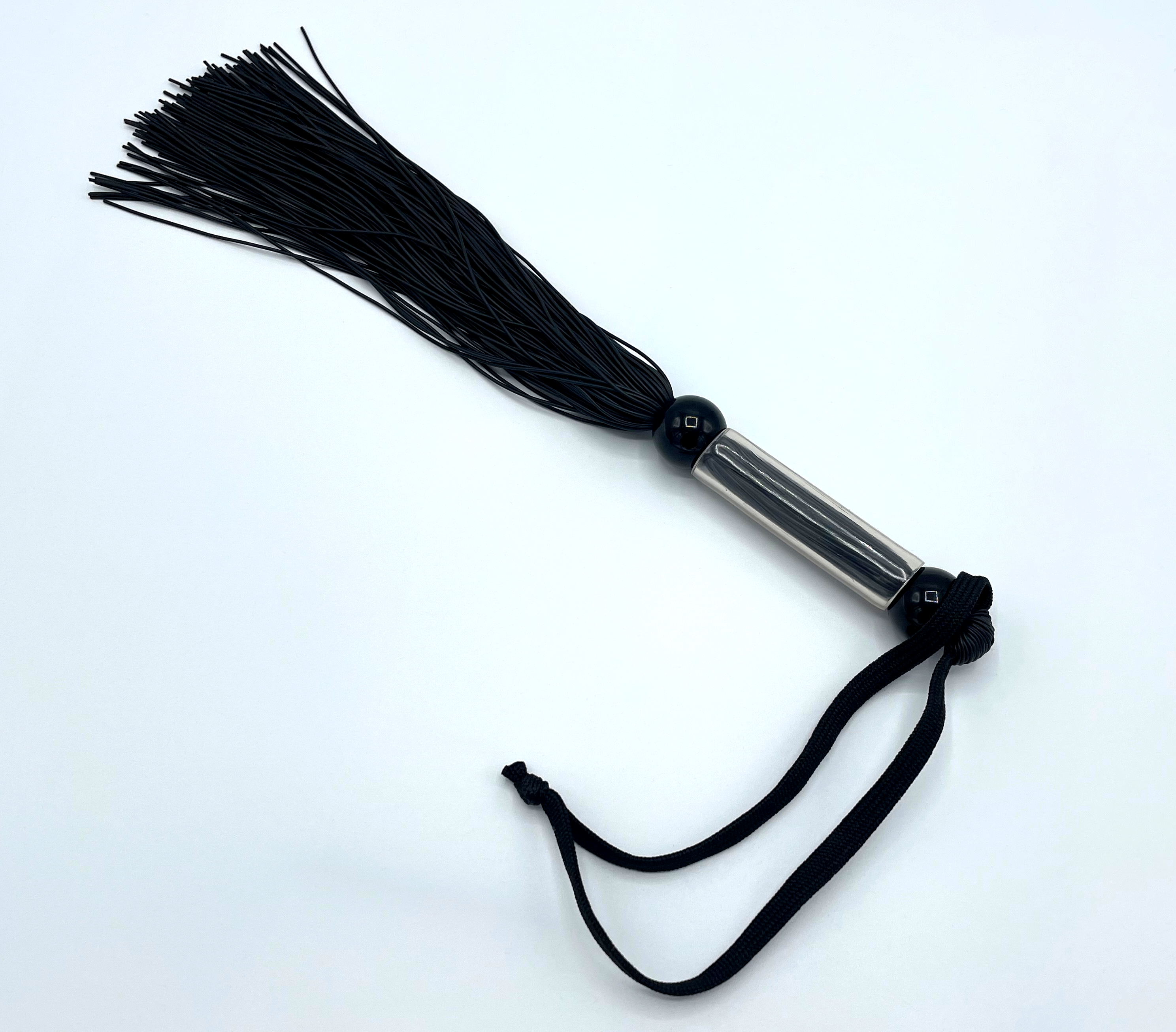 Schwarze Genitalpeitsche mit flexiblen Silikonriemen und rutschfestem Griff, ca. 27 cm lang, für gezielte Reize im Intimbereich.