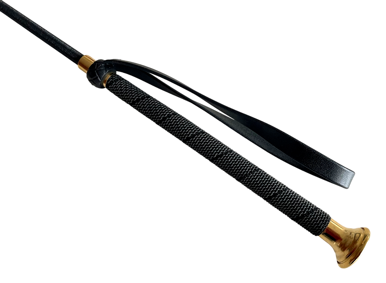 Detailaufnahme des schwarzen Griffs einer Gerte, mit Lederummantelung im Rautenmuster und funkelnden Glitzersteinen, silberne Endkappe.